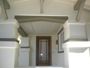front entry of stucco home after new cream paint and green trim
